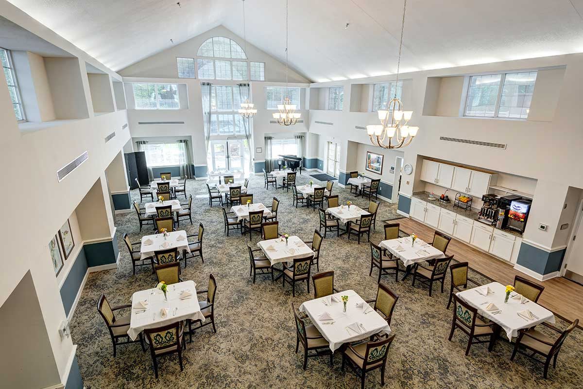 Spacious and bright dining area with neatly arranged tables and large windows.