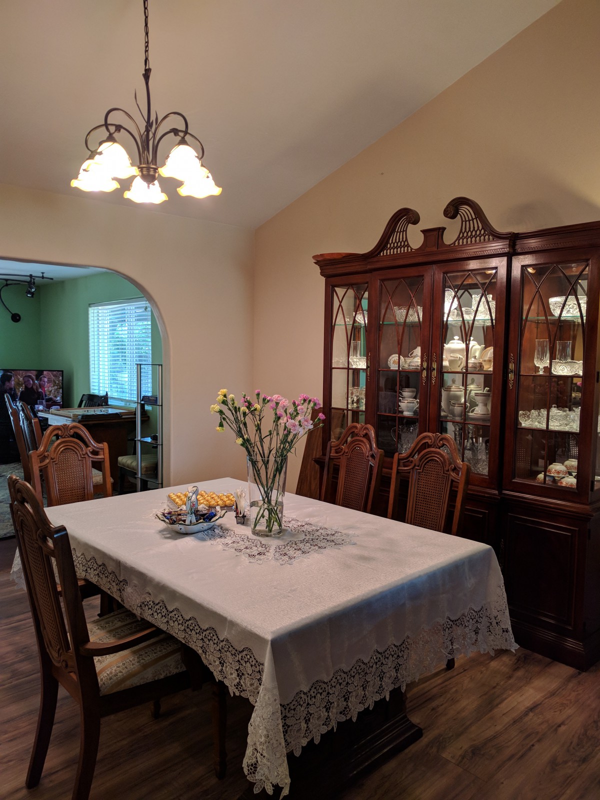 A cozy dining room with a wooden table, matching chairs, and a china cabinet.