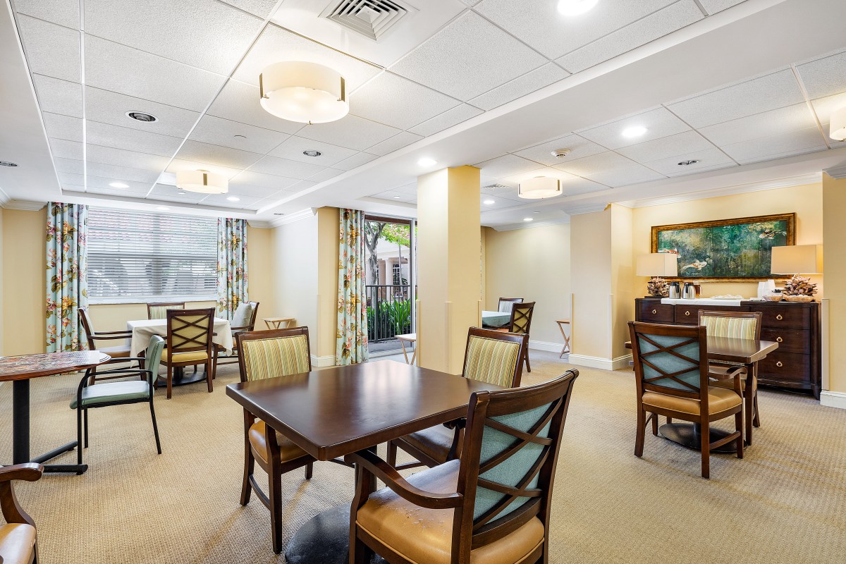 A modern and elegantly designed dining area with multiple tables and chairs, featuring warm lighting and stylish decor.