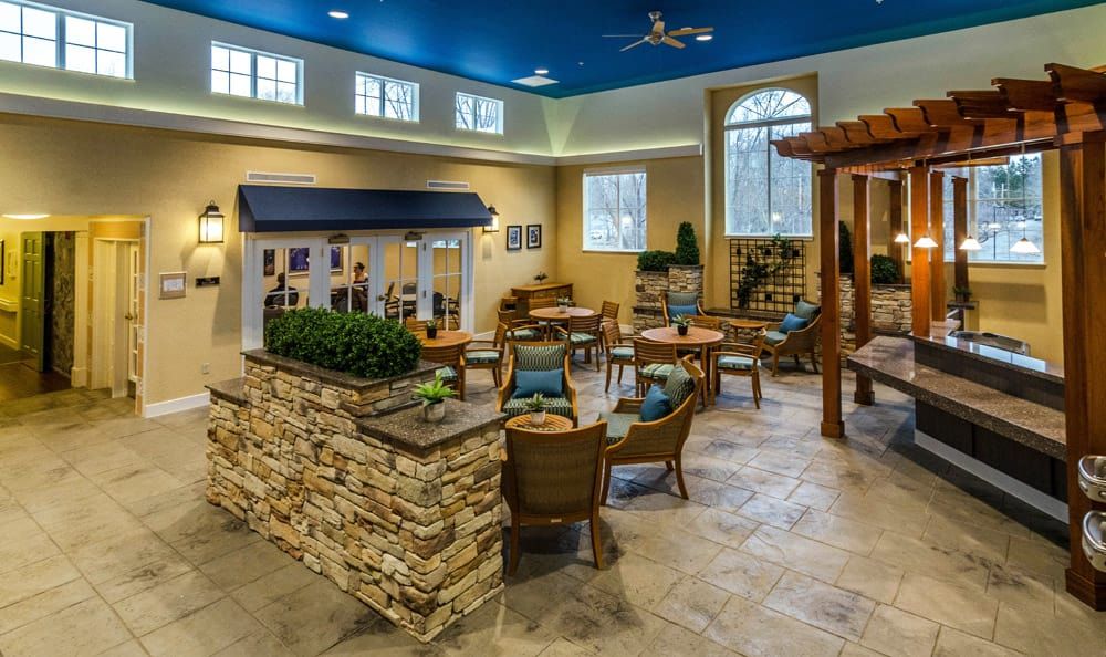 A modern lounge area with comfortable seating, decorative plants, and a stone wall feature.