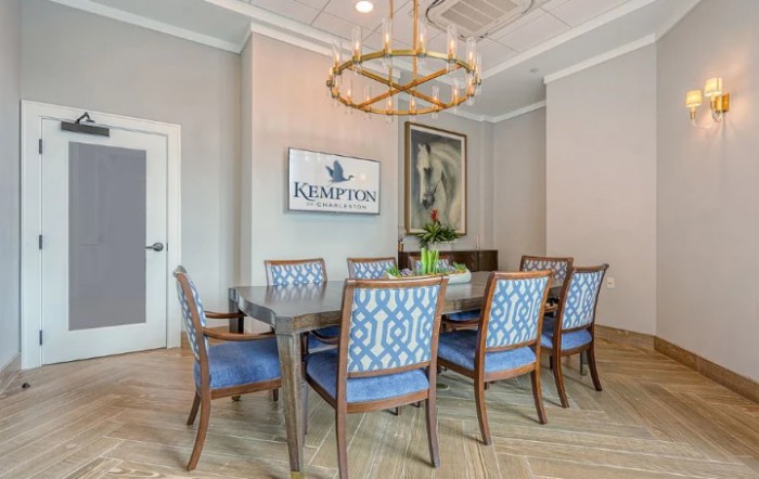 Elegant dining area with blue upholstered chairs and a modern chandelier.