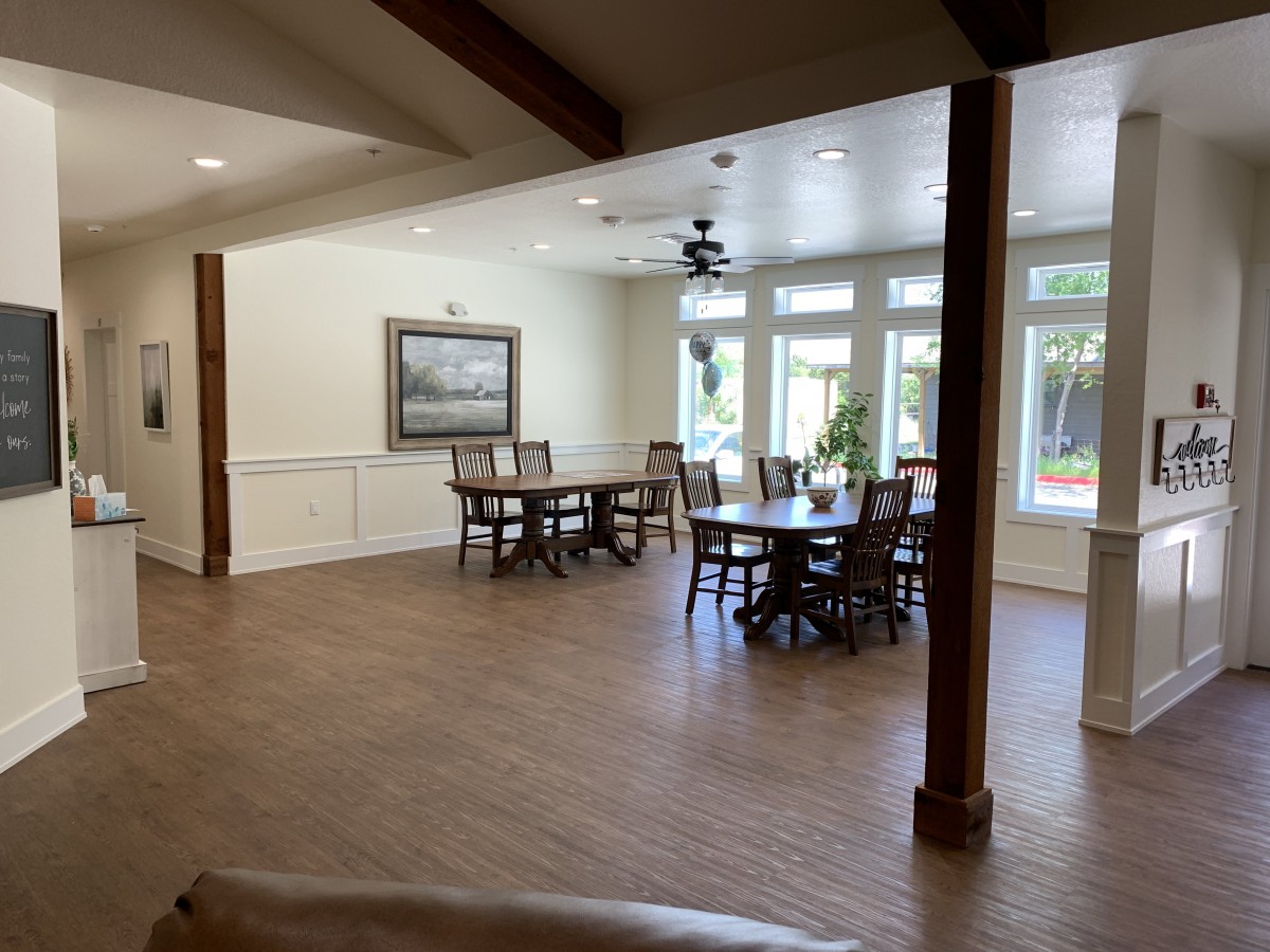 A spacious dining area with wooden floors and large windows allowing natural light to flood the room.