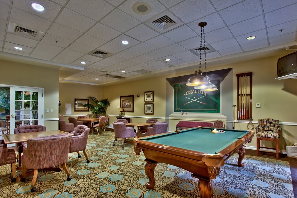 A well-furnished recreation room featuring a pool table and comfortable seating areas.
