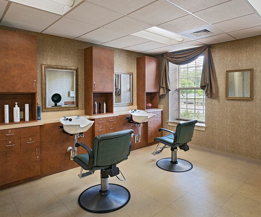 A modern hair salon interior with styling chairs, mirrors, and sinks.