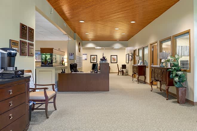 A spacious office lobby with a reception desk and seating area.
