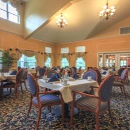 A spacious dining area with elegantly set tables and comfortable seating.