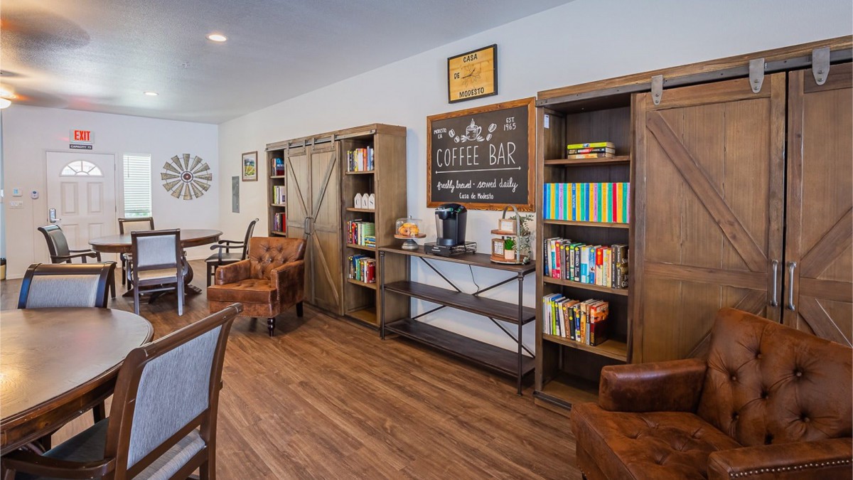 A cozy coffee shop interior featuring bookshelves and rustic decor.