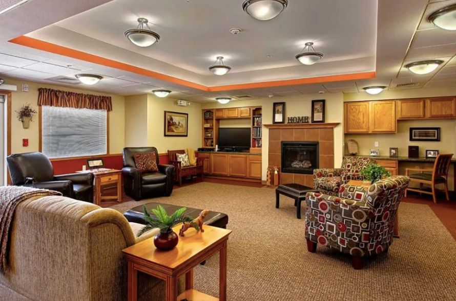 A cozy living room with comfortable seating, a warm fireplace, and a television.