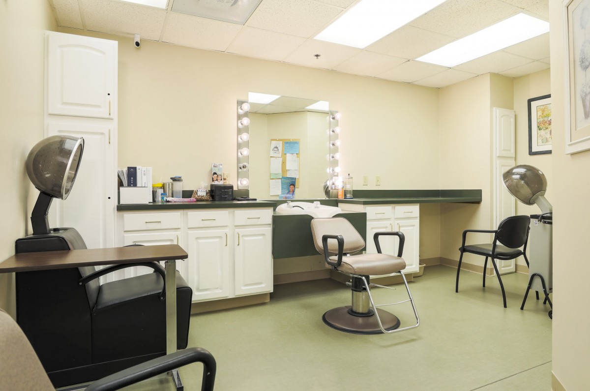 A modern hair salon with a styling station, mirror, and chairs.