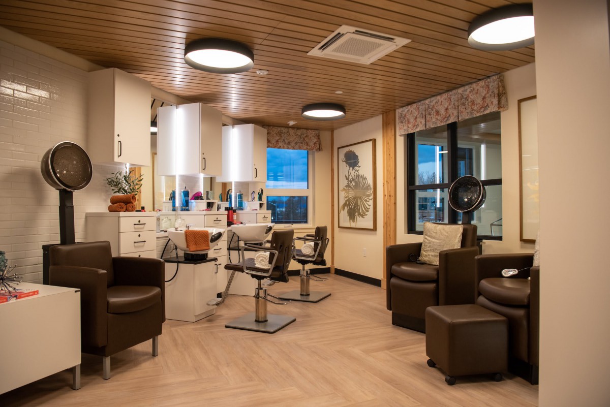 A modern hair salon interior with styling chairs, mirrors, and professional equipment.
