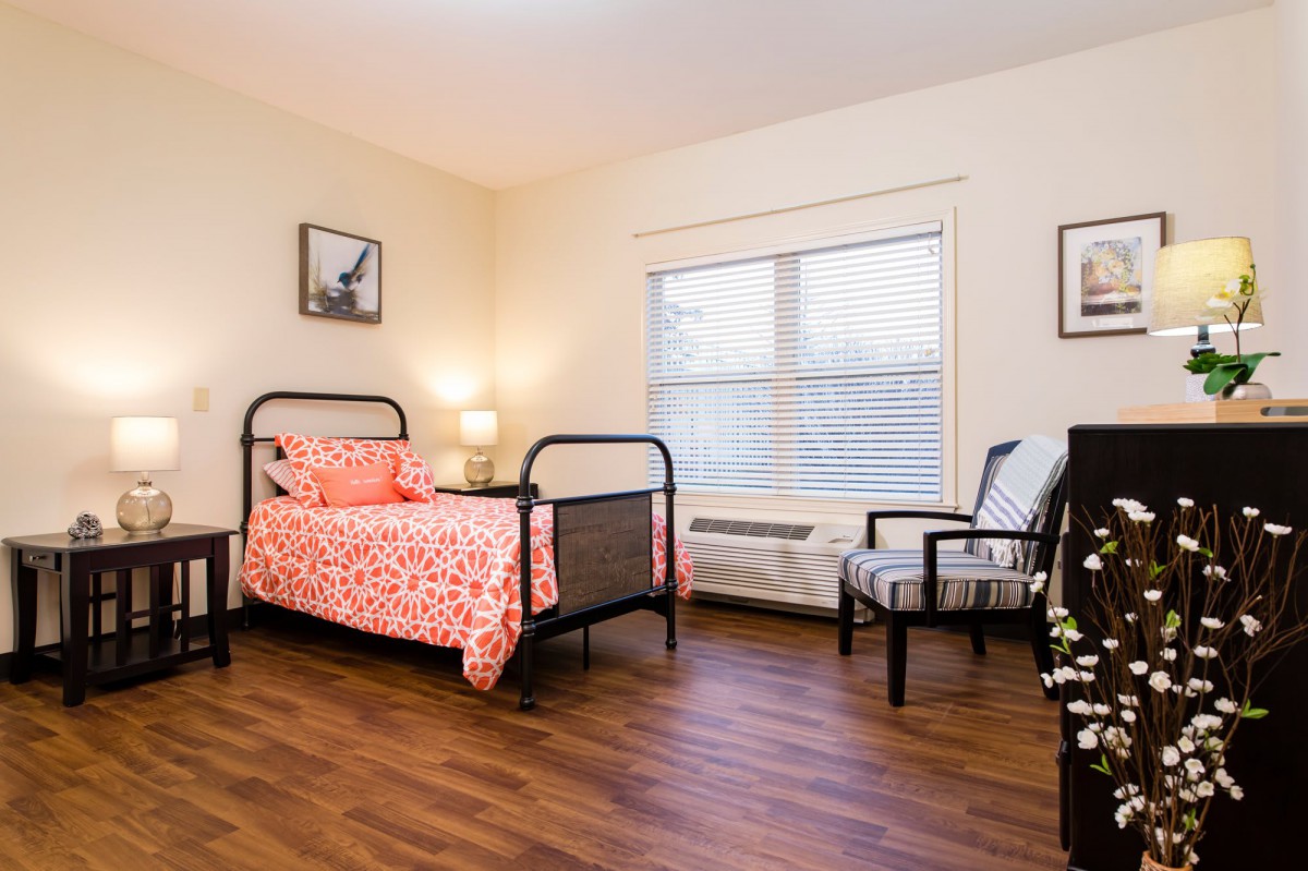 A cozy bedroom with a single bed, wooden floor, and stylish decor.