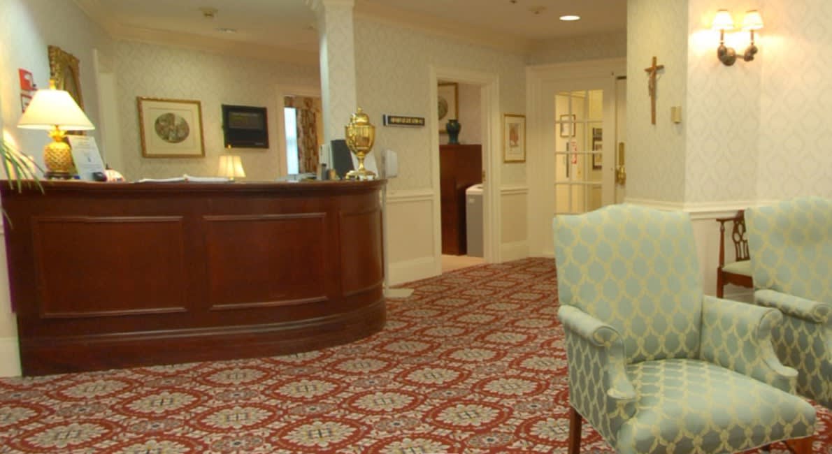 A cozy hotel lobby with a reception desk and classic decor.