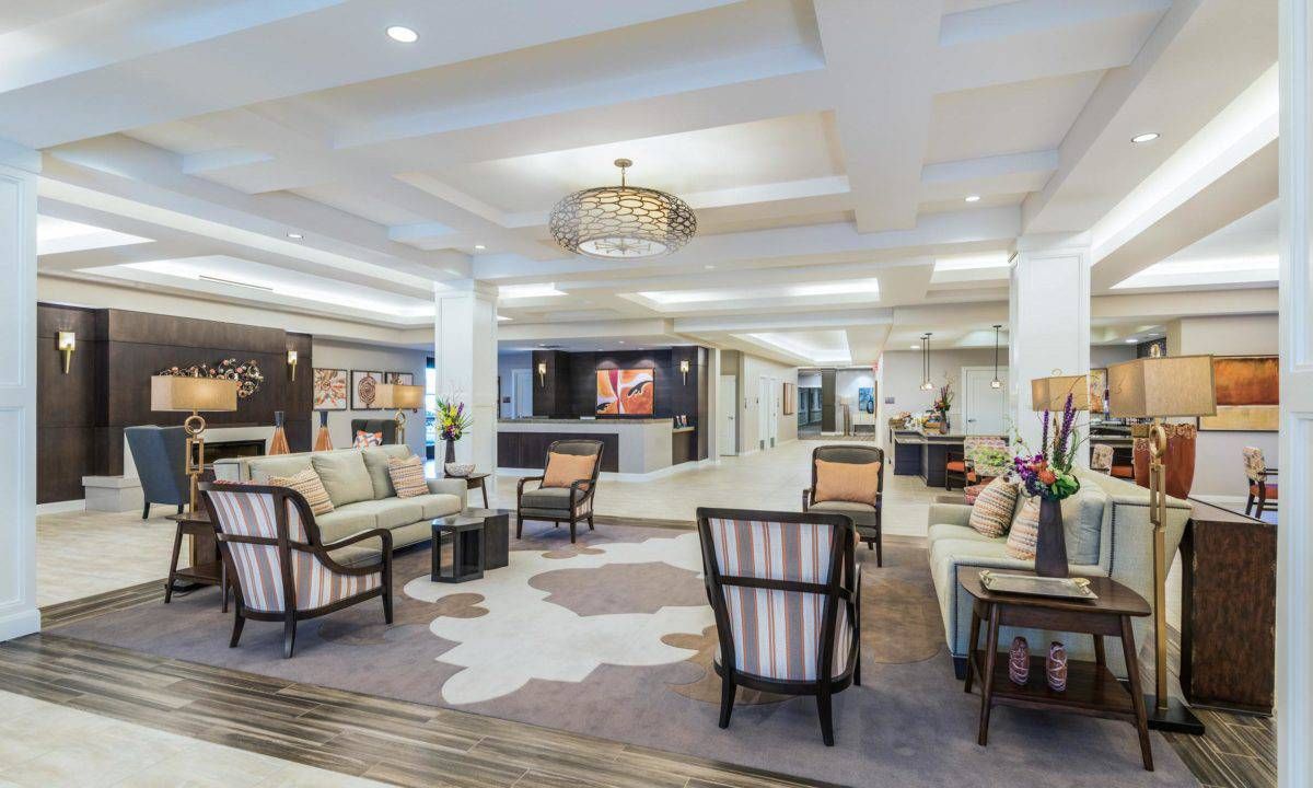 A spacious and elegantly designed hotel lobby featuring comfortable seating arrangements and a chandelier.