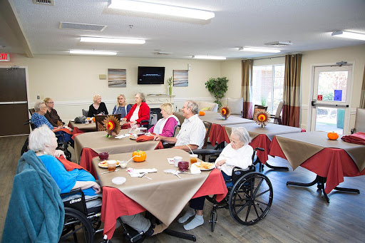 Elderly residents gather for a social event at a community center, sharing time and experiences together.