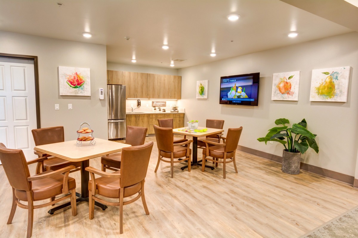A modern dining area with wooden furniture and a small kitchen.