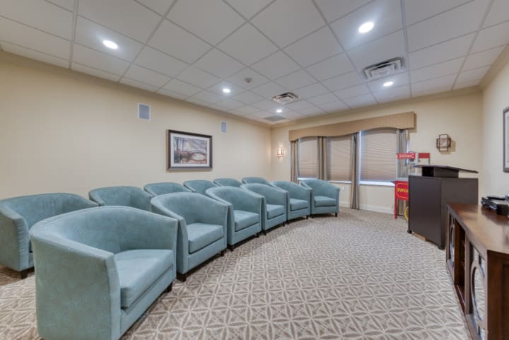 A modern waiting room with a row of comfortable chairs and a carpeted floor.