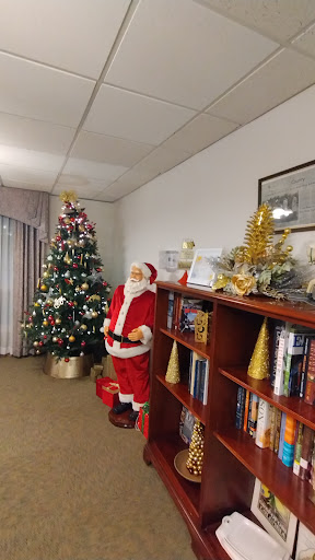 A festive corner featuring a Christmas tree and a Santa Claus figure, creating a cozy holiday atmosphere.