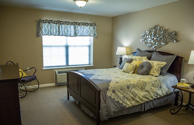 A cozy bedroom with a neatly made bed and soft lighting.