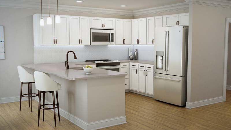 A modern kitchen with white cabinets and stainless steel appliances, featuring an island with a bar stool.