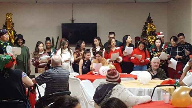 A group of people singing together during a Christmas celebration.