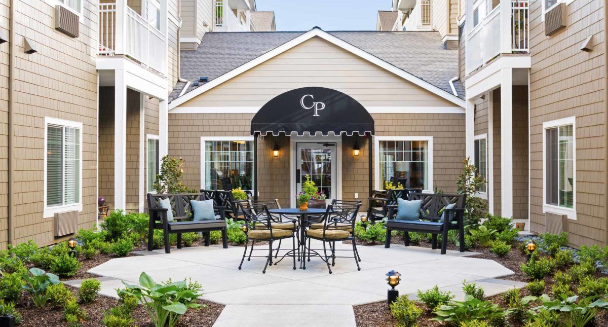 A cozy courtyard featuring outdoor seating and a building with an awning.