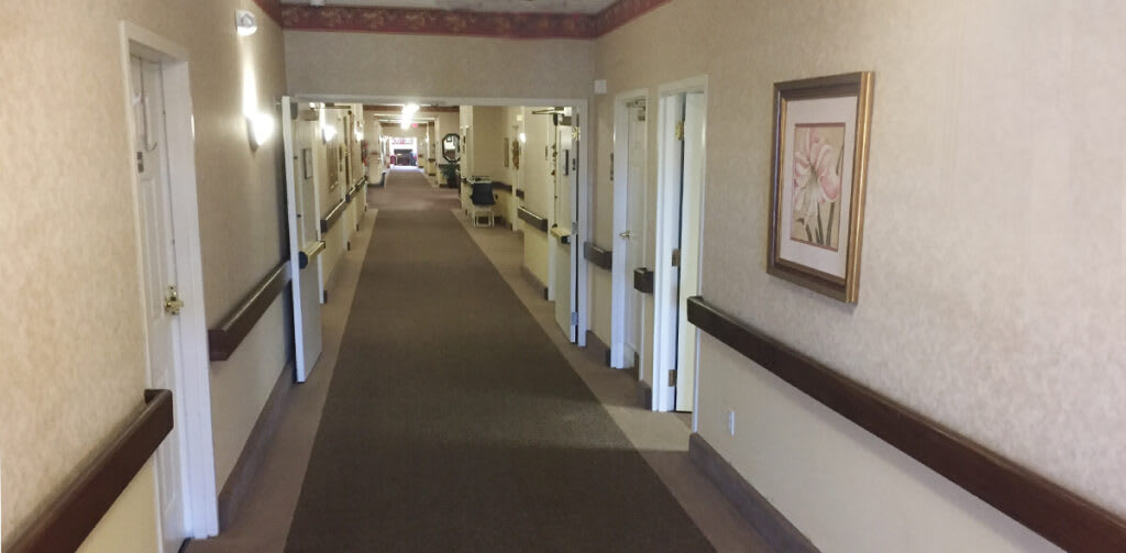 A long corridor with doors lining both sides in a building interior.