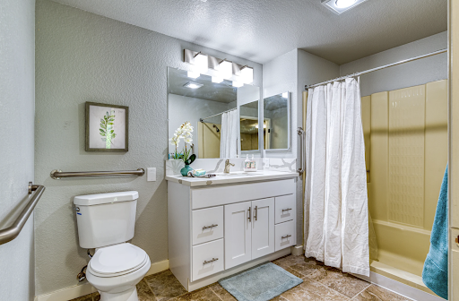 A modern bathroom featuring white cabinetry, a clean design, and functional elements.