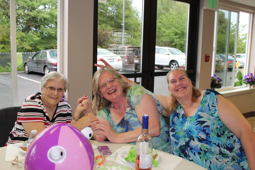 Three people enjoying a casual gathering with decorations and refreshments.