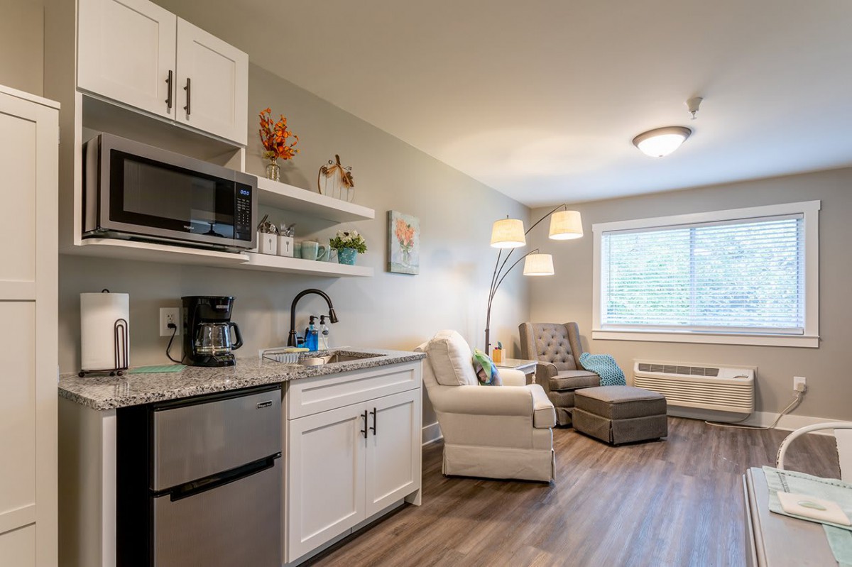 A cozy, modern living area with a small kitchen and comfortable seating.