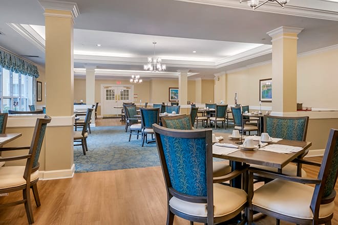 A well-lit dining area with neatly arranged tables and chairs.