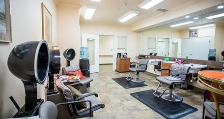 A modern hair salon interior featuring styling stations and a comfortable waiting area.