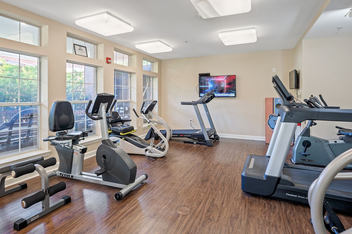 A modern gym with exercise equipment including treadmills and stationary bikes.