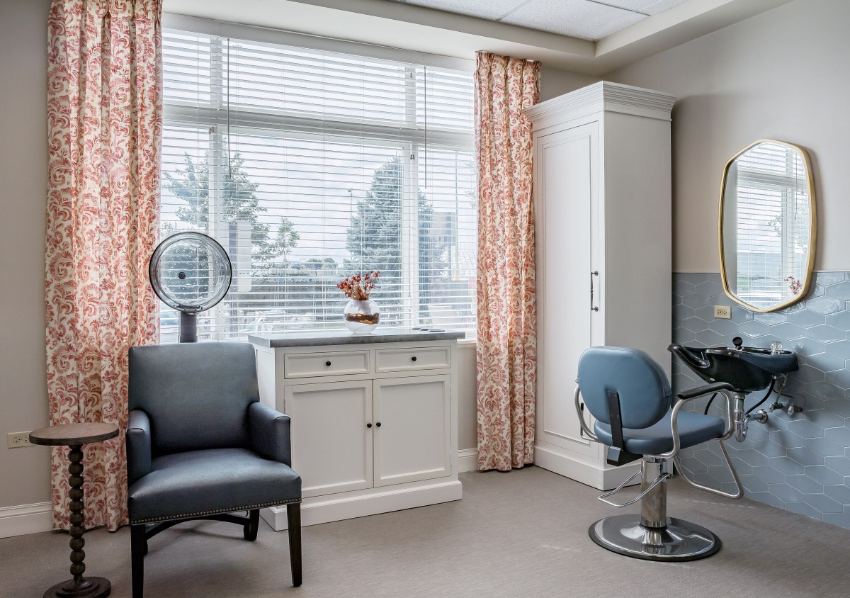 A bright and modern salon interior with chairs and a mirror by the window.