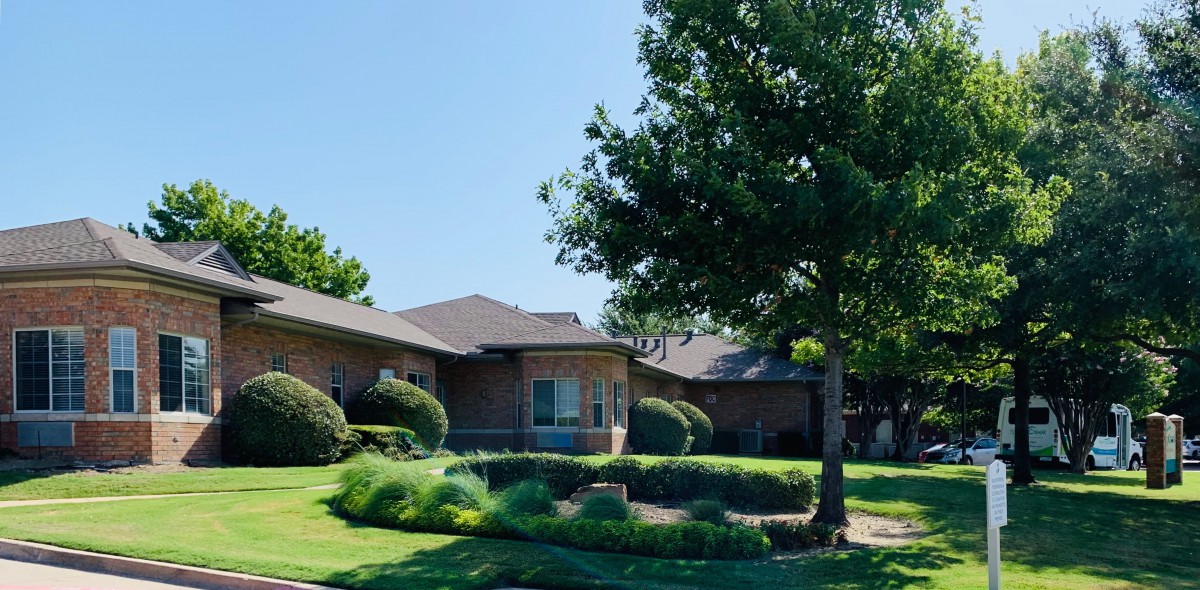 A suburban house with a well-maintained garden and lush green lawn.