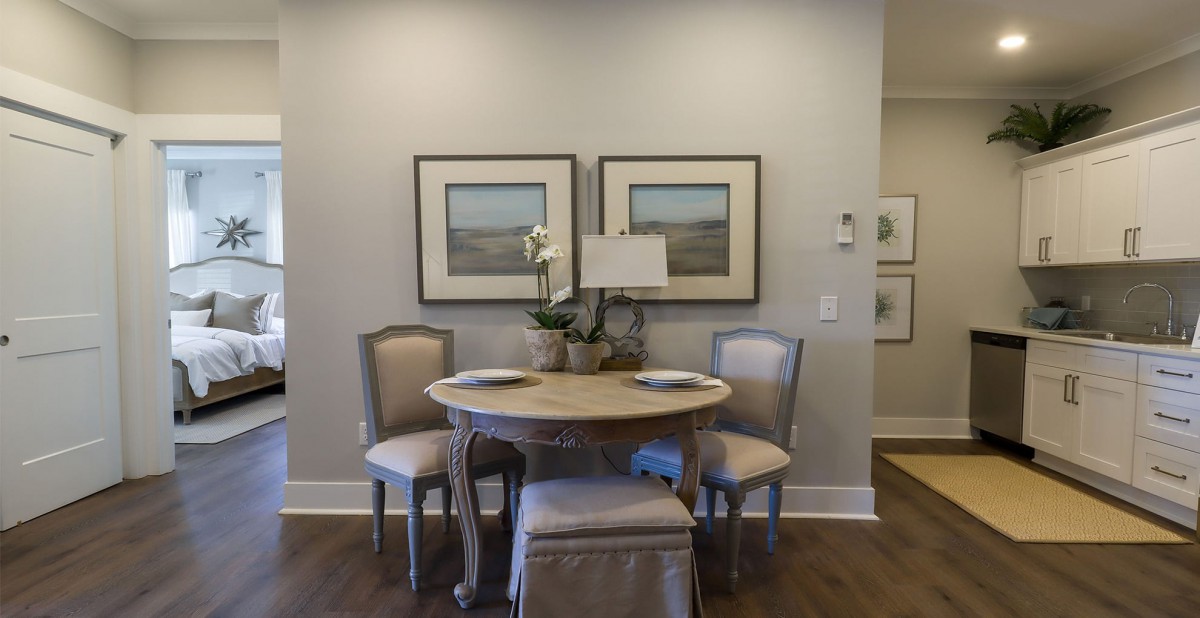 A cozy dining area with a round table, four chairs, and decorative artwork on the walls.