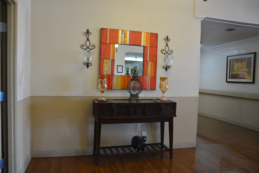 A stylish console table with an ornate mirror and decorative wall sconces.
