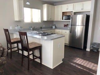 A modern kitchen with a central island and stainless steel appliances.