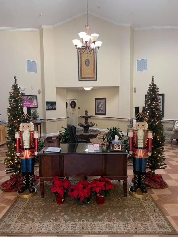 A festive indoor scene with Christmas decorations, including nutcrackers, trees, and poinsettias.