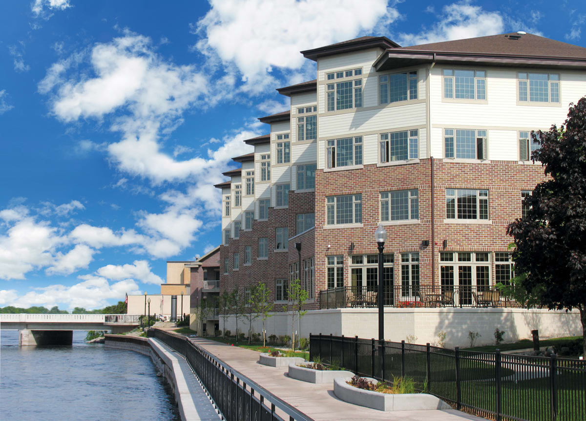 Modern riverside building with a walkway on a sunny day.