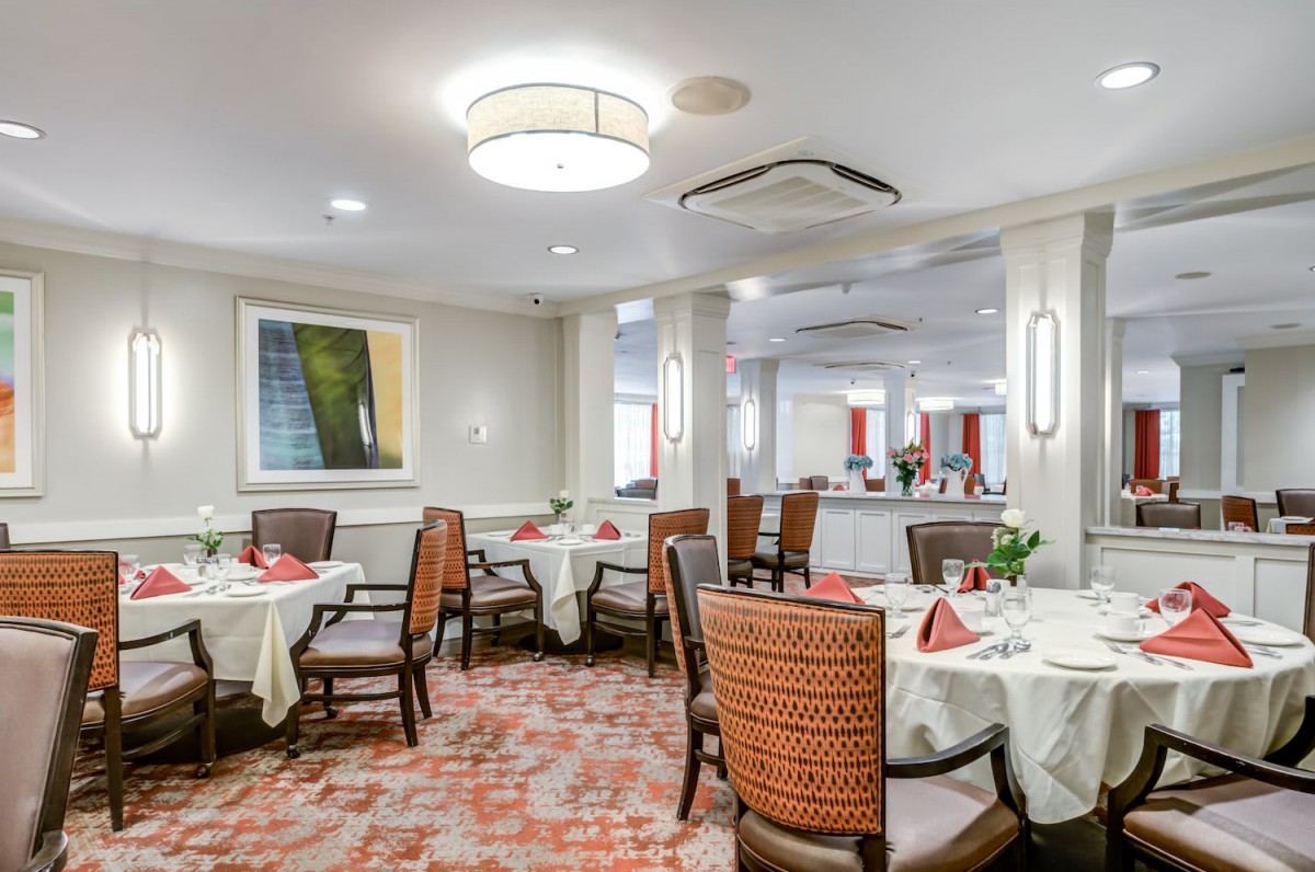A well-appointed dining room with elegantly set tables and comfortable seating.