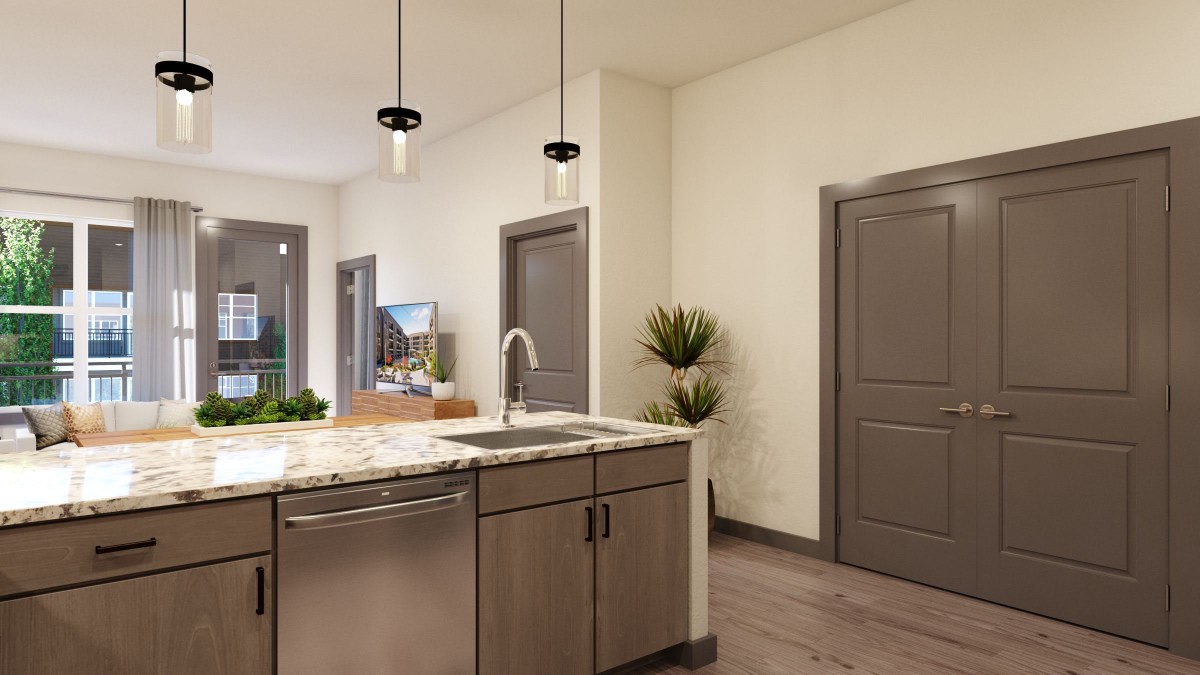 A modern kitchen interior featuring a central island with pendant lights and a sleek countertop.