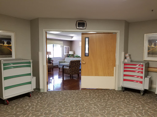 A view of an interior space with a doorway leading to a waiting area, featuring comfortable seating and decorative elements.