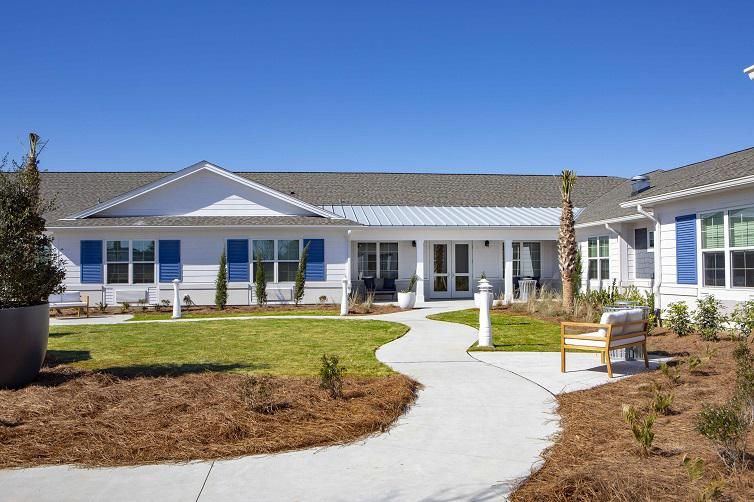 A single-story residential building with a well-maintained garden and a winding pathway.