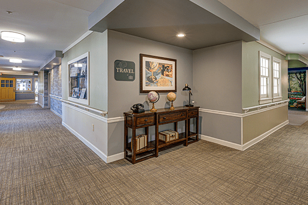 A cozy hallway with a decorated table, featuring a painting and globes.