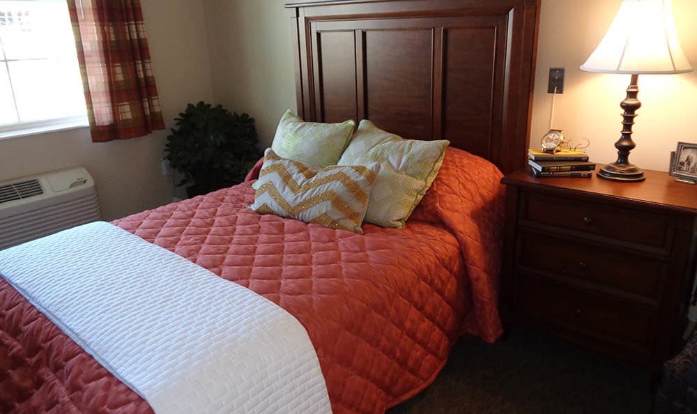 A cozy bedroom with a wooden headboard and colorful bedding.