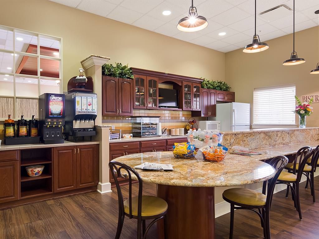 A well-furnished kitchen and dining area with wooden cabinets and a round table.