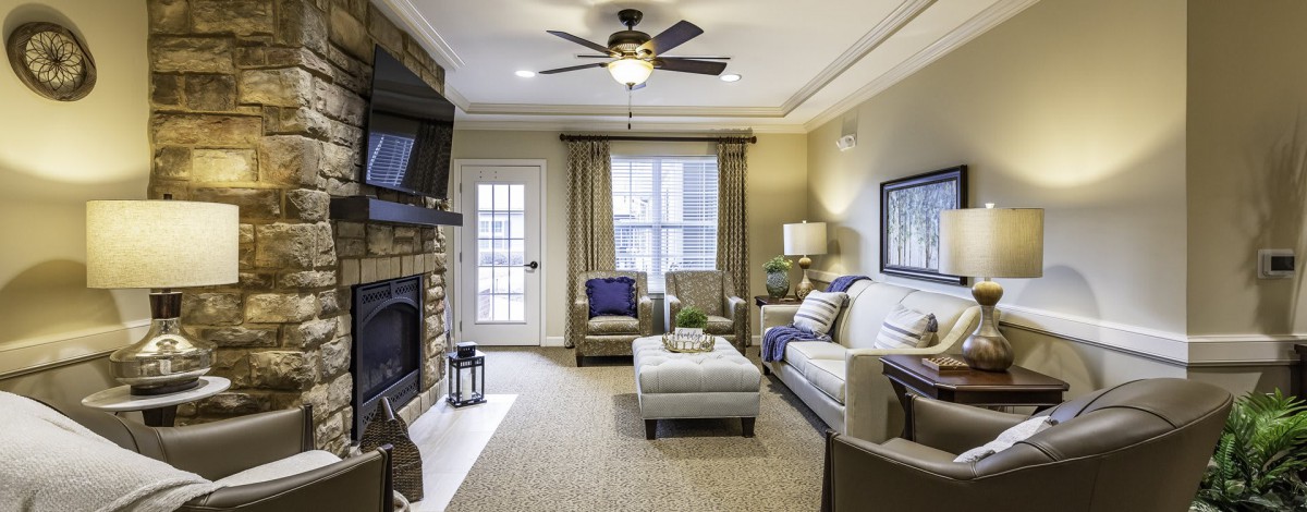 A cozy living room featuring a sofa, armchairs, and a fireplace.