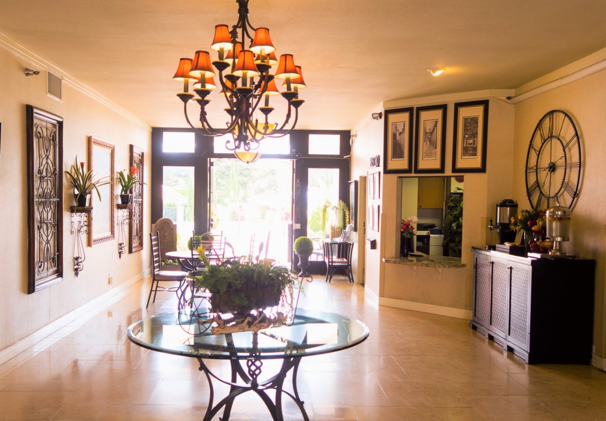 A well-lit lobby area with elegant decor and a central chandelier.