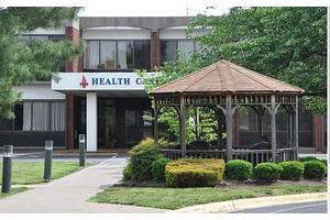 A health center building with a gazebo and landscaped garden at the entrance.