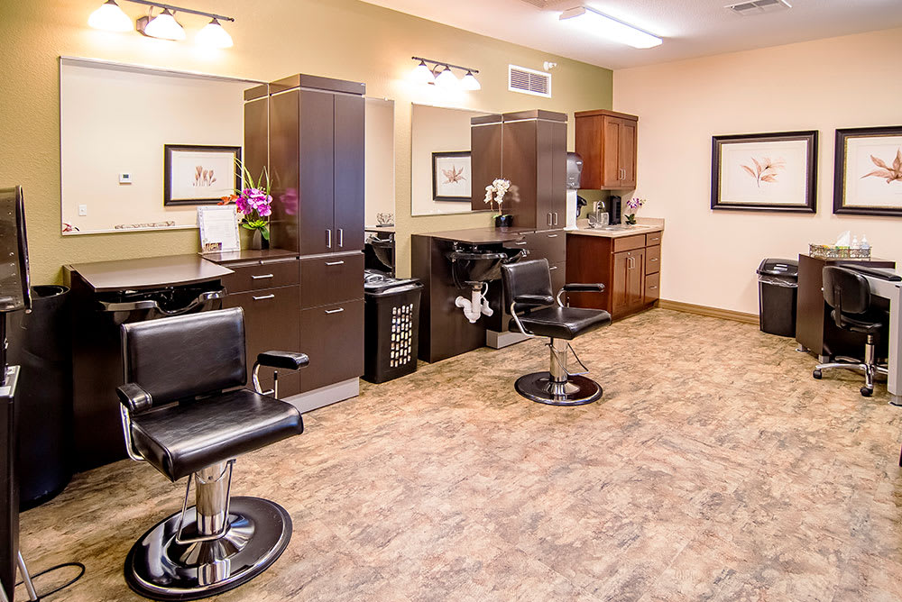 An interior view of a modern hair salon with styling stations and seating.